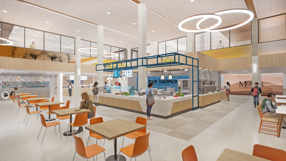 artist's rendering shows a food station labeled "true balance." in front of the station are modern wooden tables and orange chairs.