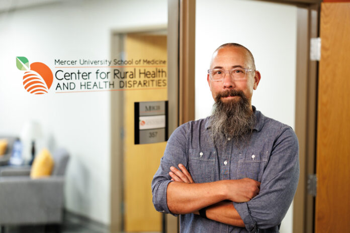 Michael Kramer standing confidently in front of the Mercer University School of Medicine, Center for Rural Health and Health Disparities.