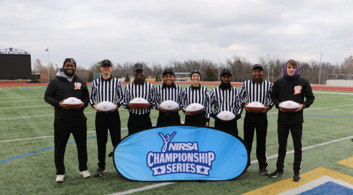 First woman from Mercer named All-American flag football official Six people wearing white and black striped official uniforms stand on a football field in front of a sign that says, "NIRSA Championship Series." They are flanked by two people wearing all black.