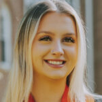 Headshot of Erin Sweat wearing red and orange stoles around her neck