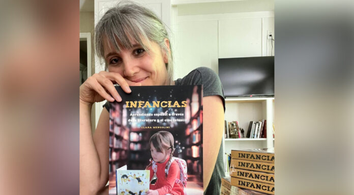 Professor writes Spanish textbook that helps students learn through children’s lit Dr. Clara Mengolini holds a book titled "Infancias."