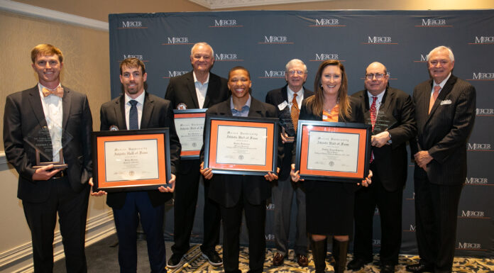 Ninth annual Alumni Awards Dinner recognizes outstanding Mercerians A group of eight individual stands in front of a Mercer backdrop, holding framed certificates and awards.