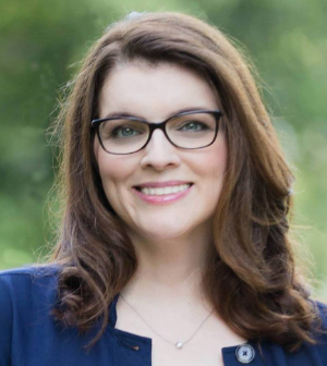 Headshot of Lauren Stinson, wearing a navy blue shirt and glasses.