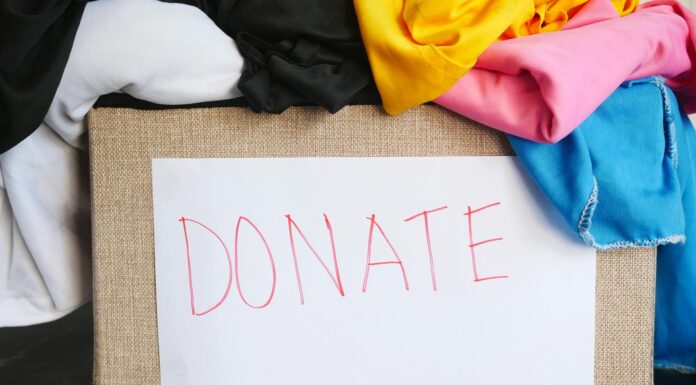Mercerians invited to donate supplies for rural areas impacted by Hurricane Helene Box overflowing with colorful fabric. A white piece of paper with the word DONATE on it is taped to the box.