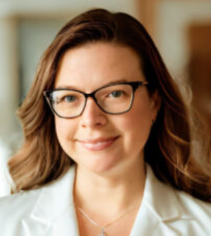 Headshot of Tara Overzat, wearing a white shirt and glasses.