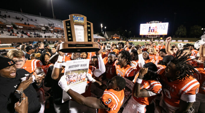 Bears’ 1st playoff game will be Dec. 7 after winning SoCon Championship outright Mercer football team celebrates on the field with a trophy and newspaper headlined History Made.