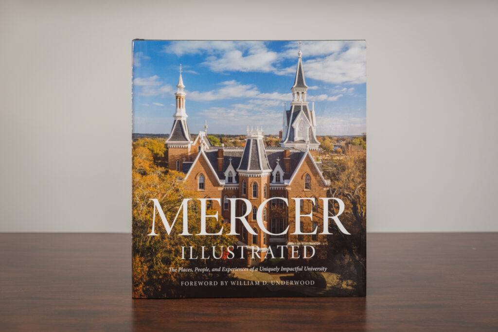 A book titled "Mercer Illustrated" with a cover photo of the Administration Building and a blue sky background.