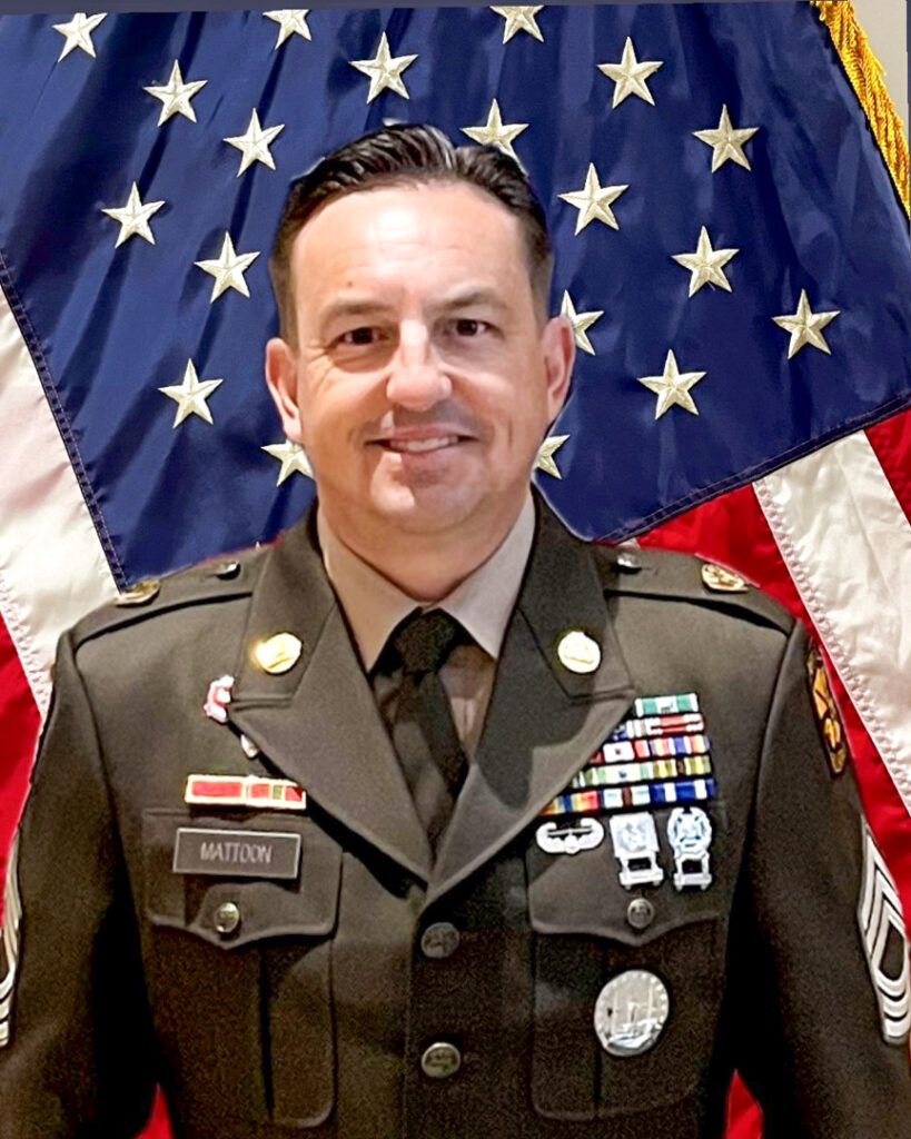 Craig Mattoon stands in front of a U.S. flag, wearing his command uniform.