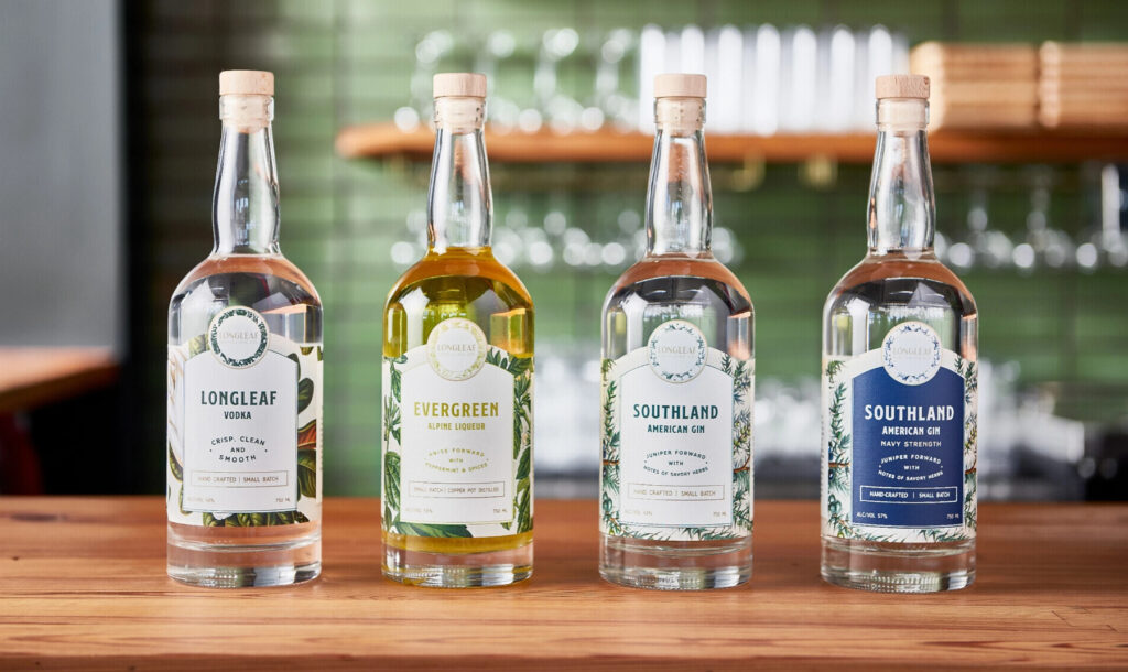 Four bottles of spirits labeled Longleaf Vodka, Evergreen Alpine Liqueur, and the last two are both Southland American Gin.