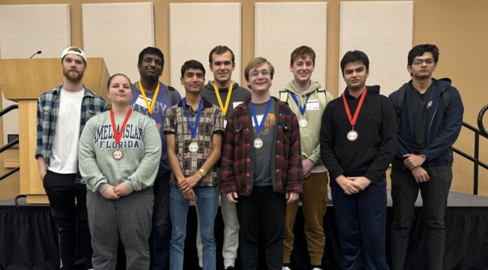 Binary Bears teams place in top 10 at international coding competition A group of nine people standing indoors, some wearing medals around their necks.