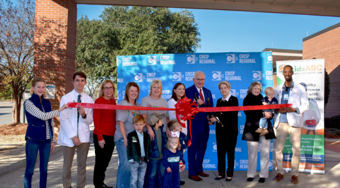 Kids Alliance for Better Care celebrates Crisp Regional Hospital’s emergency department as part of the Pediatric Emergency Care Project A group of people participate in a ribbon-cutting ceremony outside, with a red ribbon and a Crisp Regional backdrop.