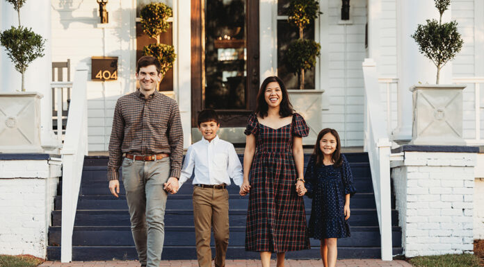 Mercer Law connections lead to marriage, jobs and home The O'Connor family of four, dressed in casual attire, walks hand in hand on a brick path in front of a white house with blue stairs.