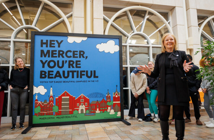 Penny Elkins talks in front of mural that reads, 