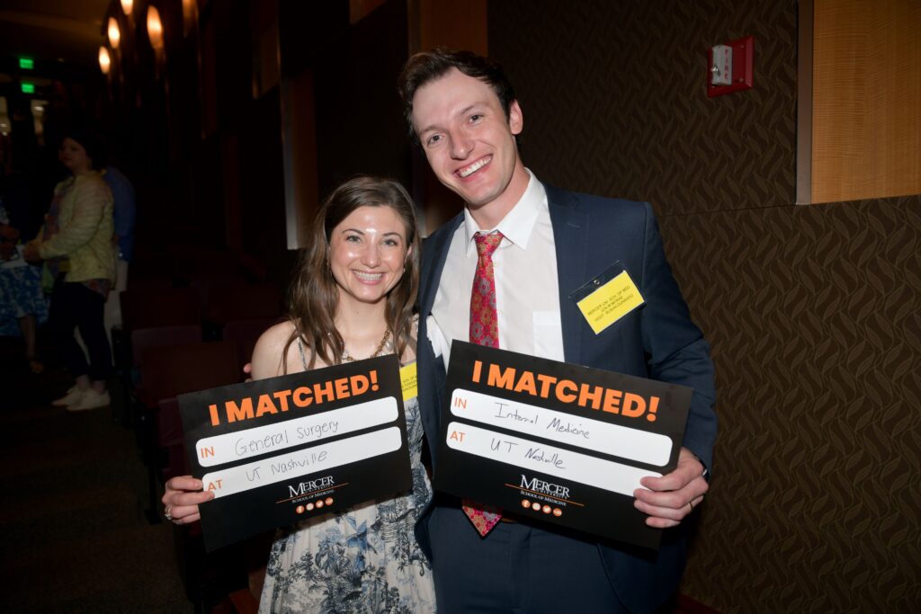 Two people smiling, holding I Matched! signs indicating their matches in General Surgery and Internal Medicine at UT Nashville.