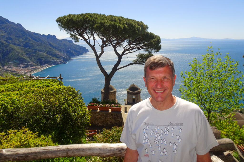 Brad Lindsey in front of a scenic coastal view in Italy.