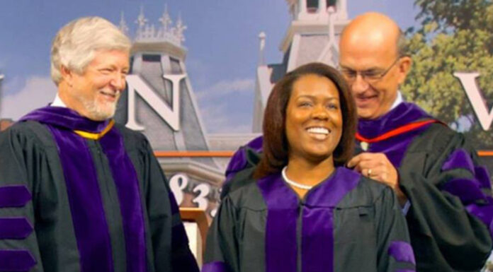 Perseverance and hard work contribute to success of Mercer Law alumna Three people in purple academic robes at a graduation ceremony; a woman is being honored while two men stand beside her, smiling.