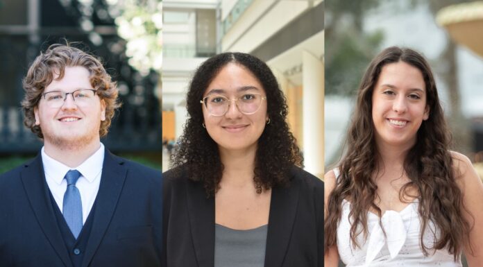 Another record year — three juniors named Goldwater Scholars Three people are posed side by side. Two are wearing suits, and one is in a white dress, all smiling at the camera.