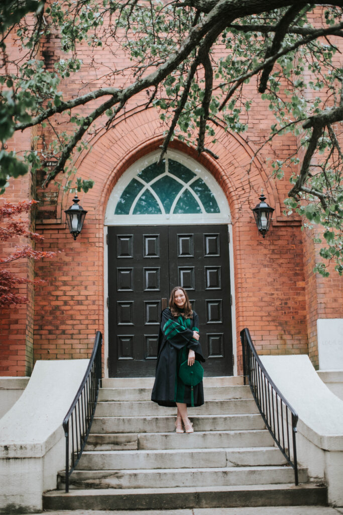 Madison Adams wears a green and black graduation robe.