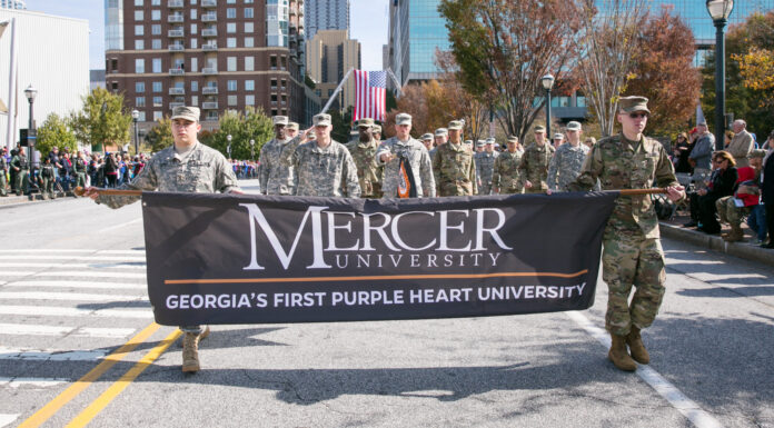 Mercer ranked as No. 1 Military Friendly® School for third straight year A group of people in military uniforms carrying a Mercer University banner during a street parade.