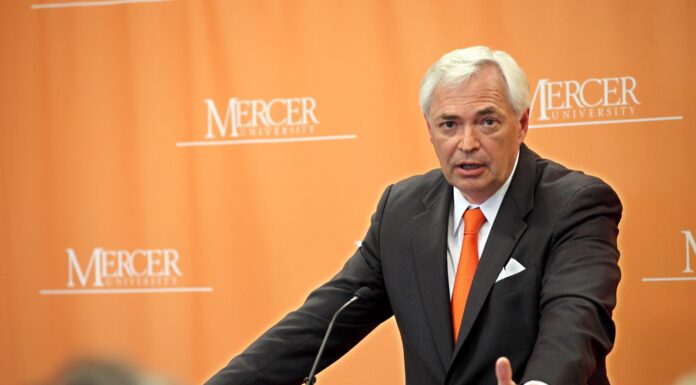 Underwood led Mercer through tremendous growth and development Mercer President William D. Underwood speaks at a podium in front of an orange Mercer University backdrop.