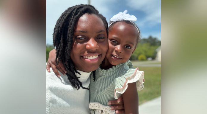 Mercer graduate’s personal journey becomes catalyst for advocacy An adult and a young child smile outdoors, with the child wearing a white bow and green striped dress.