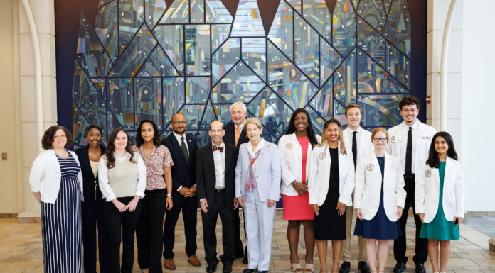 School of Medicine celebrates 2025 Children’s Healthcare of Atlanta Rural Scholars A group of people, some in white coats, pose for a photo indoors in front of a large, colorful stained glass mural.