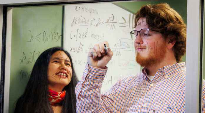 Goldwater Scholar’s research could help make autonomous driving safer Dr. Makhin Thitsa and Wesley Kinney work at a glass window covered with mathematical equations. Kinney is writing while Dr. Thitsa observes.