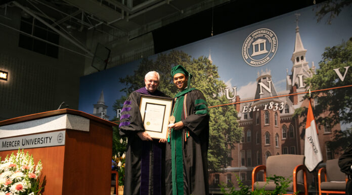 School of Medicine graduate honored with Algernon Sydney Sullivan Award Mercer President William D. Underwood presents Myles Nicholas Duncan with a framed award.