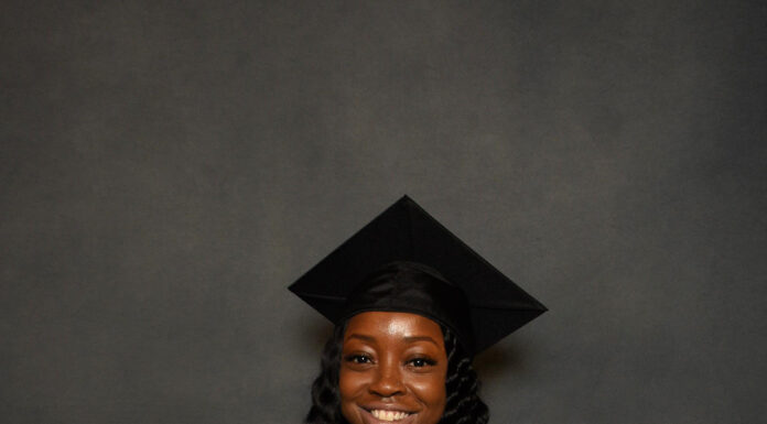 Graduate Spotlight: Aeeril Johnson Aeeril Johnson in a graduation cap and gown holds a Mercer University diploma and smiles at the camera.