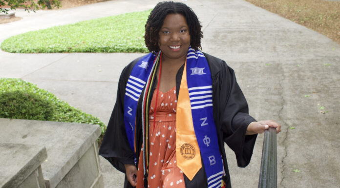 Graduate Spotlight: Bree Withrow Bree Withrow, in graduation attire, stands on outdoor steps.