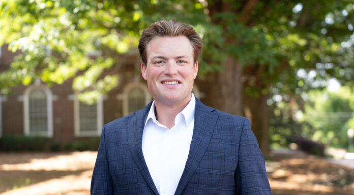 Mercer law student feels called to be a force for good in society Colby Belland stands outdoors, smiling, with trees and a brick building in the background.