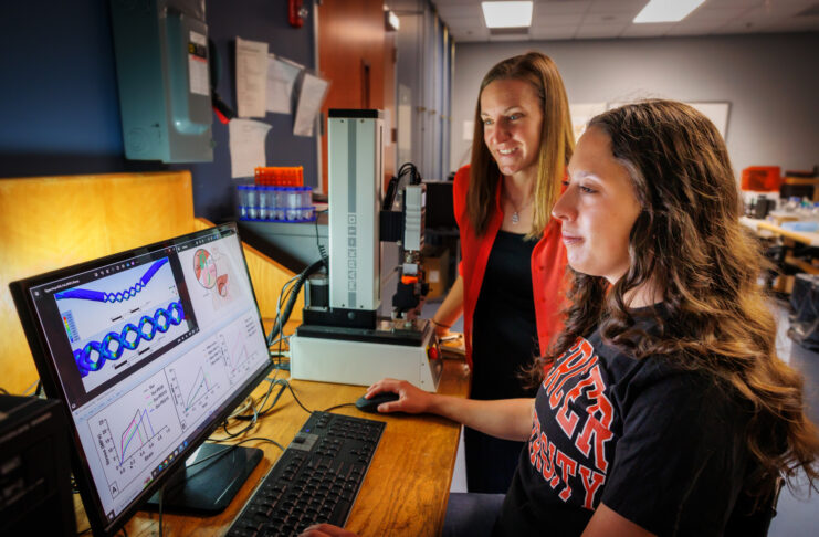 Ainsley Westbrook and Dr. Joanna Thomas are in a lab reviewing scientific data displayed on a computer monitor.