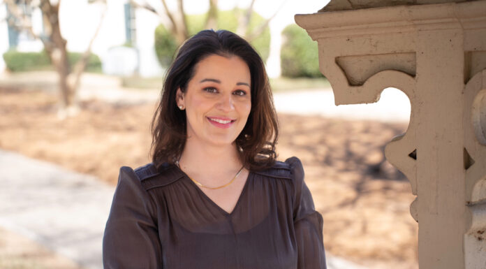 Mercer law graduate wants to be an advocate for older adults Elizabeth Nelms smiles while standing outdoors near a decorative wooden structure.