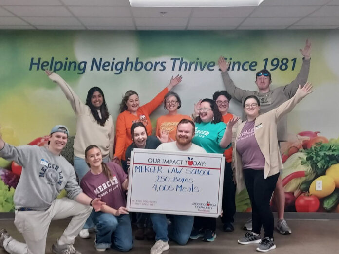 food frenzy 2 A group of people poses indoors, holding a sign that reads, Mercer Law School: 250 Boxes, 4,005 Meals.
