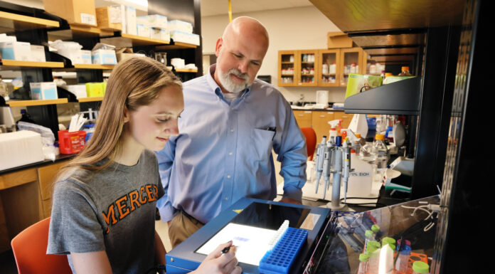 Dr. Garland Crawford named assistant vice provost for research A student and a professor observe lab results on a screen in a science laboratory surrounded by equipment and supplies.