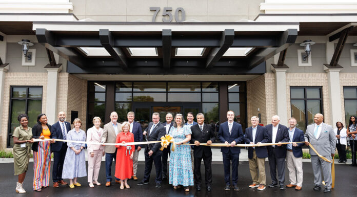 Mercer partners to open center for adults with intellectual, developmental disabilities A group of Mercer University representatives as well as state and local Georgia officials stand in front of a building holding a large ribbon at a ribbon-cutting ceremony.
