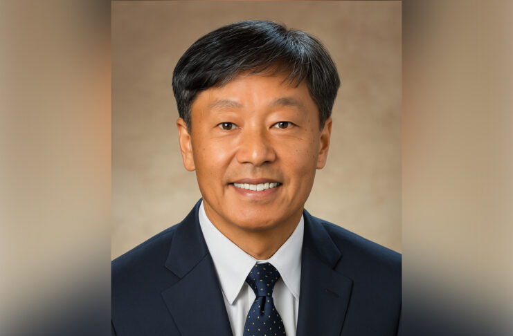 Dr. Chang Y. Chung smiles at the camera against a neutral brown background.