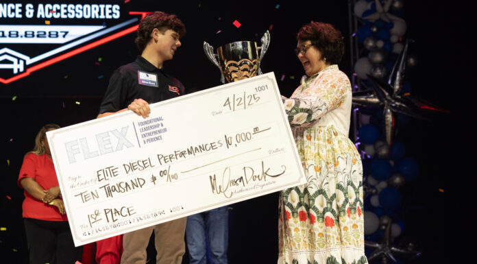 Mercer alumna founds program to support young entrepreneurs A young man receives a trophy and a $10,000 check for first place at an event, standing beside a woman on stage.