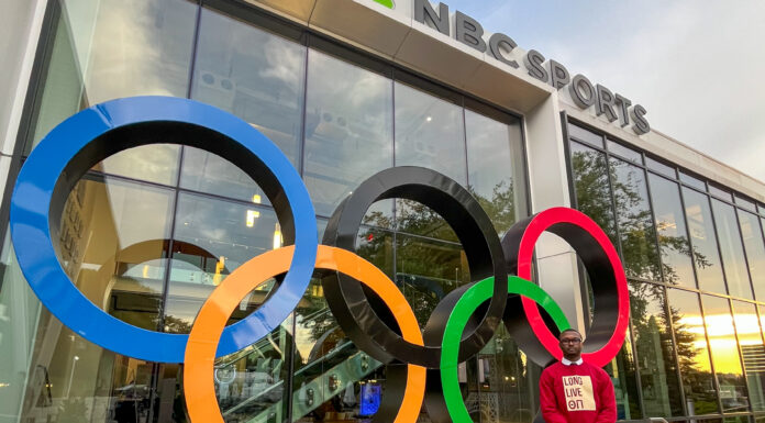Mercer alumnus worked on Emmy-winning team during NBC Sports internship Person stands beside large Olympic rings sculpture outside an NBC Sports building.