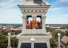 Mercer one of Princeton Review’s ‘Best Colleges’ for 23rd consecutive year Four people stand in a white clocktower holding a Mercer University flag, with campus buildings visible below.