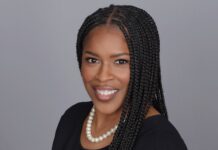 School of Medicine announces Ieesha Johnson as featured speaker for 2025 Greenberg-Williams Lectureship Woman with long braided hair wearing a black dress and pearl necklace, smiling against a plain gray background.