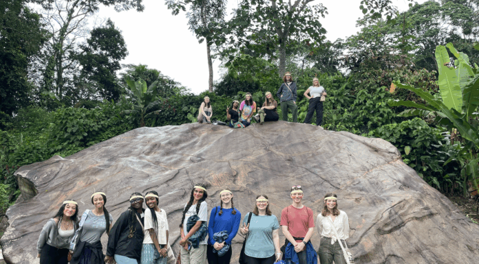 Mercerians help preserve environmental knowledge in the Amazon A group of people pose in front of and on top of a large rock in a lush, green outdoor setting.