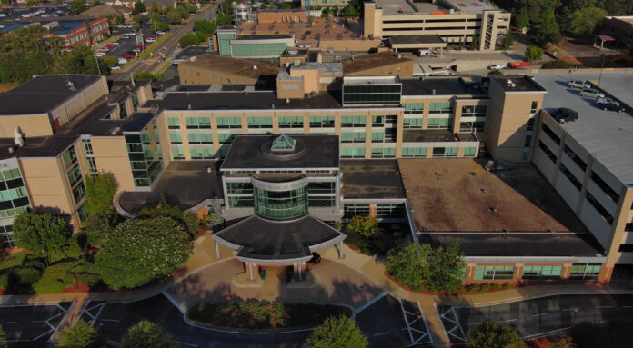 Tanner-CarrolltonCampus-Den-Photo Aerial view of a Tanner Health medical complex with multiple buildings, parking areas, and landscaped greenery.