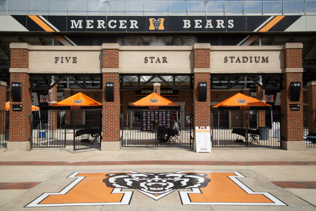 Entrance to Mercer University’s Five Star Stadium, featuring gates, orange umbrellas, and Mercer Bears branding.