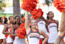 3 things to know about Mercer vs. Samford football game day: Oct. 4, 2025  A group of Mercer University cheerleaders in uniform hold orange pom-poms outdoors, one cheering with arm raised.