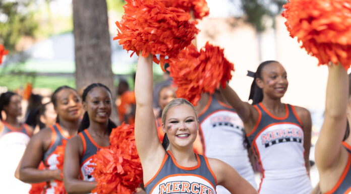3 things to know about Mercer vs. Samford football game day: Oct. 4, 2025 A group of Mercer University cheerleaders in uniform hold orange pom-poms outdoors, one cheering with arm raised.