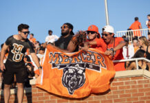 3 things to know about Mercer vs. Wofford football game day: Sept. 13, 2025 Four fans cheer at a sports event, holding a Mercer Bears flag and wearing Mercer University apparel.