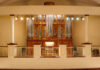 Handcrafted organ brings ‘new dimension’ to Mercer’s music programs A large pipe organ with ornate woodwork is displayed behind a railing in a well-lit concert hall.