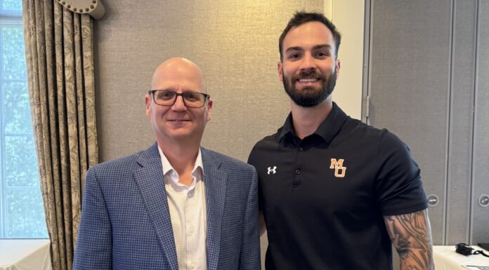 Criminal justice, public safety leadership student receives Metropol continuing education scholarship Two men stand side by side indoors; one in a blue blazer, the other in a black polo and light pants.