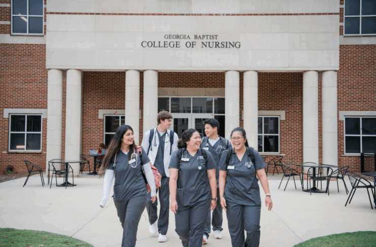 Five nursing students walk and talk outside the Georgia Baptist College of Nursing building.